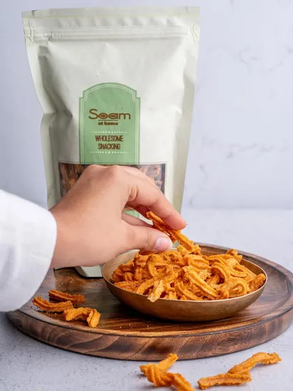 A hand reaches for a Soya Stick from a bowl, with the convenient resealable bag in the background. It's a snack shelf staple for any time cravings.