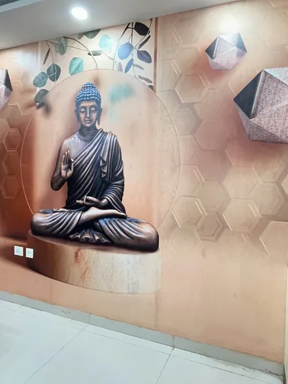 A finished installation of a modern Buddha wallpaper. The design features a geometric background and subtle leaf motifs, creating a calm and contemporary spiritual space.