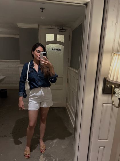 A casual mirror selfie in a denim shirt and white shorts. An easy, classic combo for a warm day.