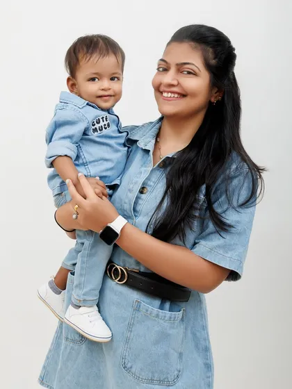 A mother and her "cute much" son in matching denim outfits, sharing a sweet moment for the camera.