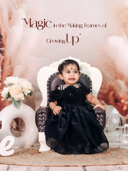 A dramatic and elegant first birthday portrait. The little girl, dressed in a beautiful black gown, sits like royalty against our bohemian pampas grass studio backdrop.