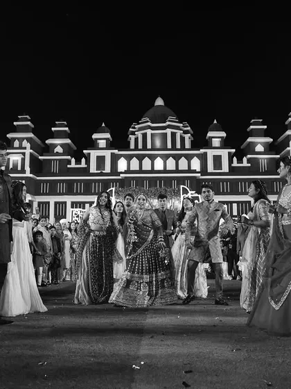 A wide-angle shot of the wedding venue, showing guests gathered to celebrate the couple against the backdrop of a grand, palace-like structure we helped create.