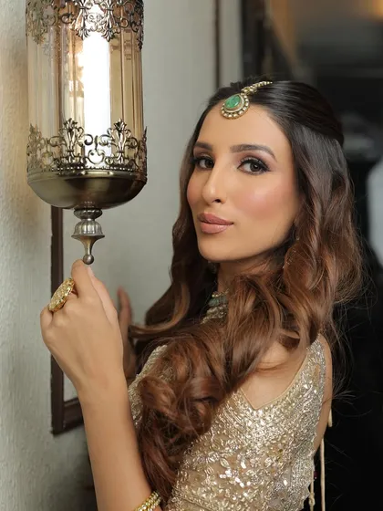 A creative pose using the warm lighting to create a beautiful ambiance. The makeup looks radiant and glowing in this shot.