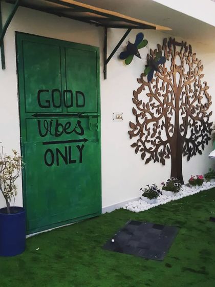 The 'Good Vibes Only' door next to the tree of life wall art, a combination that creates a positive and artistic entrance.