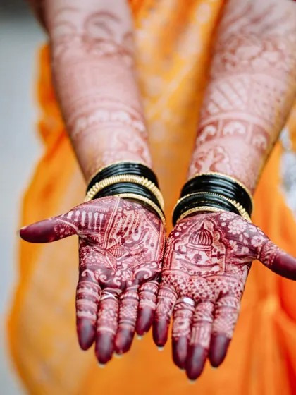A close-up shot of the bride's hands, showcasing the intricate henna design.