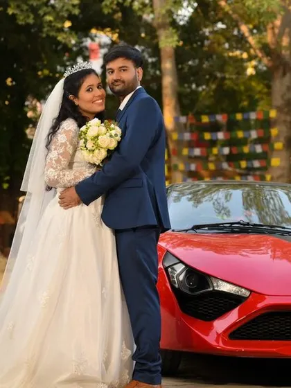 I love capturing all types of weddings, including beautiful Christian ceremonies. Here, the bride and groom are posed with a vibrant red sports car, adding a modern and stylish touch to their classic wedding portraits.