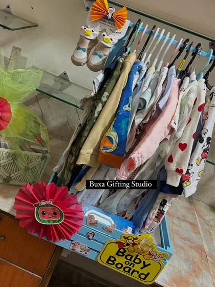 A baby's first wardrobe is so special. This hamper tray creatively displays a collection of baby clothes and essentials, making it a practical and beautiful gift.