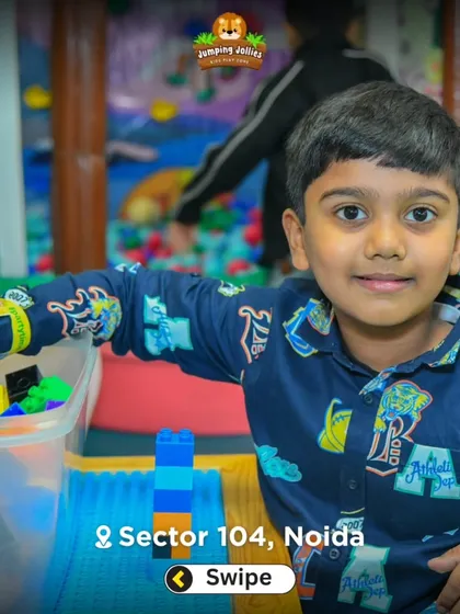 A child focused on building a tower with interlocking blocks. I provide various creative play stations to engage different interests.