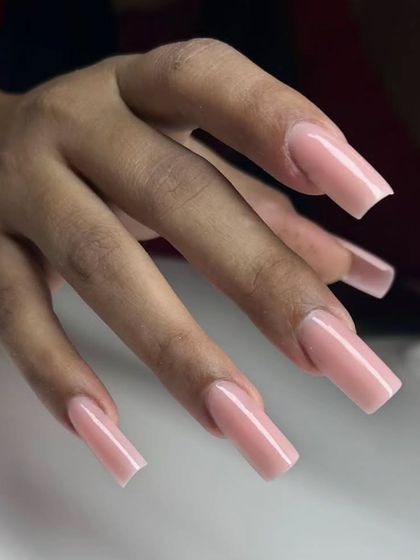 A perfect set of long, square nude nail extensions. This is a clean, classic, and versatile look that elongates the fingers.
