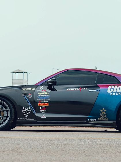 A heavily stickered Nissan GTR, a true icon of the drag racing world, sits ready on the track. The "Cloud 9" branding shows a great example of vehicle wrap sponsorship.