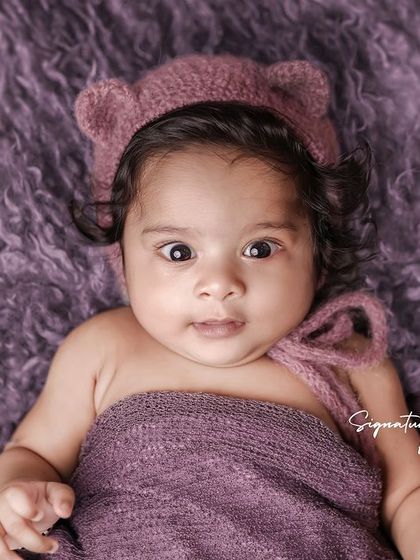 The beautiful, wide-eyed gaze of a four-month-old baby. We also offer sessions for older babies to capture their developing personalities.