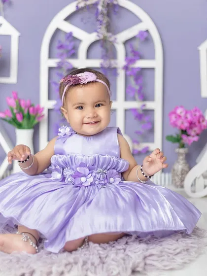 A perfect, happy portrait of a one-year-old princess in her beautiful purple dress.