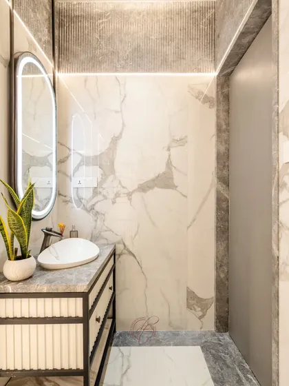 The vanity in this bathroom is a statement of modern elegance, with a fluted design, a sleek vessel basin, and a suspended oval LED mirror.