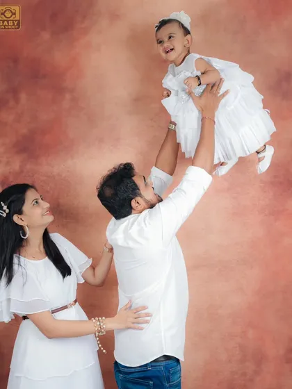A playful and dynamic family shot, with the father lifting his daughter up in the air, creating a moment of pure delight.
