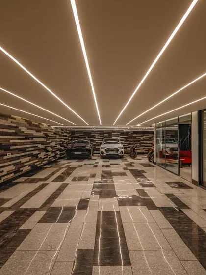 We believe luxury is in the details, and that extends to every part of a home. For this project, we designed a parking area with custom stone inlay flooring and a textured wall, transforming a utilitarian space into a design statement.