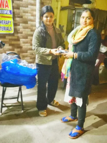 A woman gratefully accepts a muffler. Our goal is to ensure everyone feels the warmth of community support during the winter.