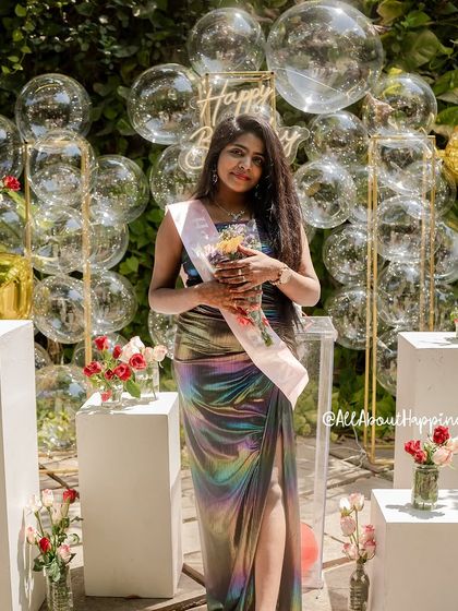A full shot of the birthday girl in her beautiful iridescent dress, which perfectly complements the shimmering bubble decor.