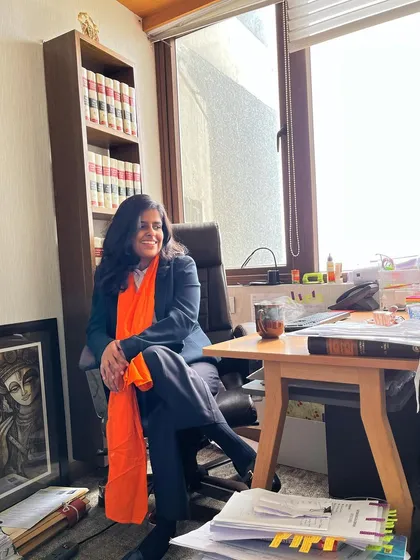 Taking a moment in my office chair. The space is filled with legal texts and personal touches that make it my second home.