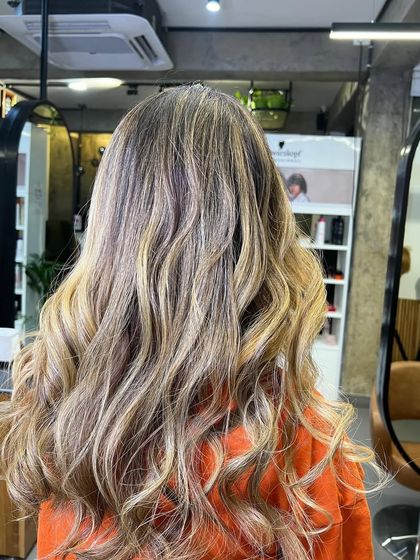 Another view of the same lived-in blonde balayage, showing the beautiful, flowing waves and seamless color blend.