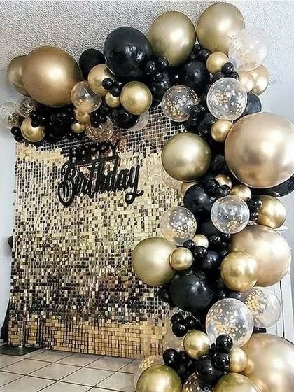A glamorous black and gold sequin backdrop with an extravagant balloon arch, perfect for a grand celebration.