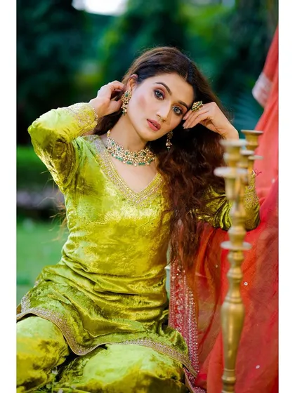 An outdoor fashion shoot for an ethnic wear brand, focusing on the vibrant color of the velvet fabric and intricate jewelry. We use natural light and professional equipment to capture true-to-life textures and details.