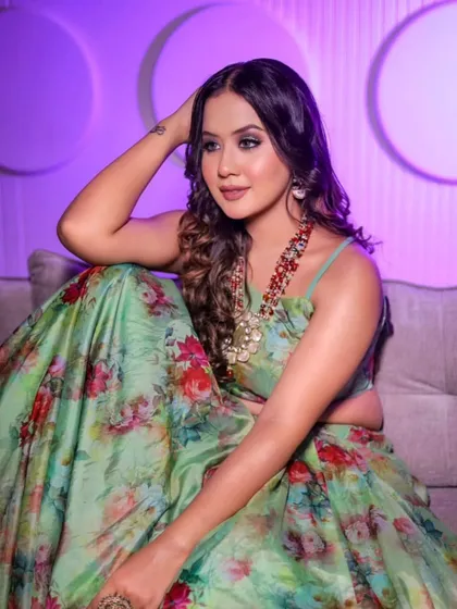 A relaxed pose in the green floral lehenga, showing its versatility and comfort. It's an easy-to-wear yet stylish option for any festive gathering.