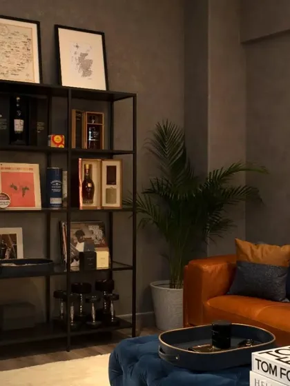 A close-up of the den's shelving unit, curated with the client's collection of fine whiskeys, books, and personal memorabilia.