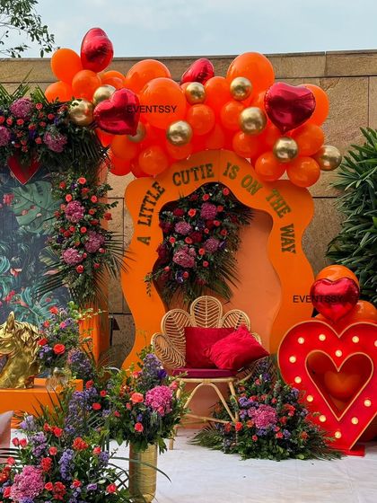 This angle showcases the seating area next to the main backdrop, complete with a comfortable peacock chair and plush cushions. It’s designed to be the perfect spot for the guest of honor to relax and take photos.