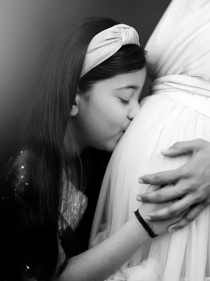 Sometimes, the most powerful stories are told without a single word. This tender black and white moment of a big sister's kiss is a perfect example of a family maternity picture, filled with love and anticipation for the new arrival.