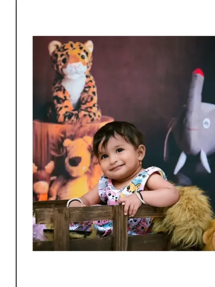 A charming, sly smile from this little one during her jungle animal photoshoot. Leaning on the edge of a wooden crate, she looks like the queen of her own little kingdom.