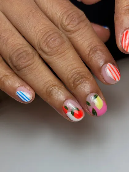 A fresh and fruity set. This design features a mix of hand-painted lemons and apples with fun striped and checkered patterns for a playful, summery vibe on short nails.