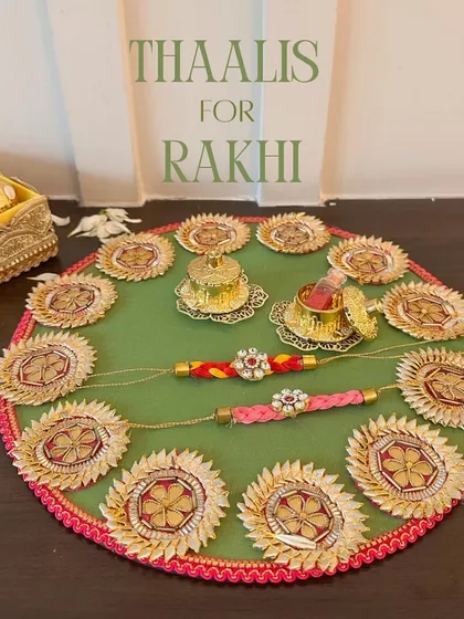 This traditional green and pink gota patti Rakhi thaali is perfect for a vibrant celebration. It comes complete with matching rakhis and ornate containers for roli and chawal, capturing the festive spirit beautifully.
