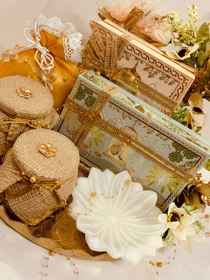 An overhead view of our golden round tray hamper, showcasing the intricate arrangement of Pichwai-style boxes and jute-covered jars. It is a masterpiece of traditional design and luxury.
