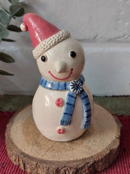 This adorable mini snowman, with his carrot nose and cozy scarf, is ready to bring a smile to your face. He's the perfect size for a mantel or tiered tray display.