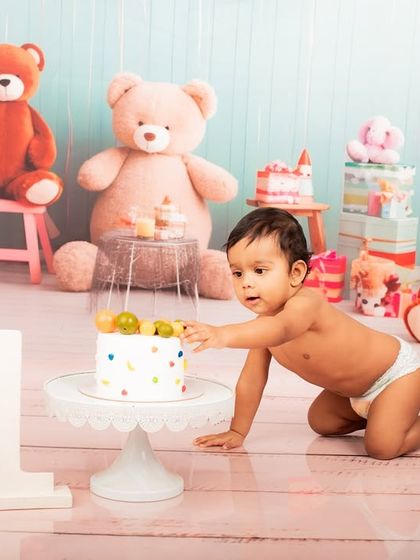 Reaching for the prize. This shot captures the baby's curiosity and excitement as he gets his first touch of the birthday cake.