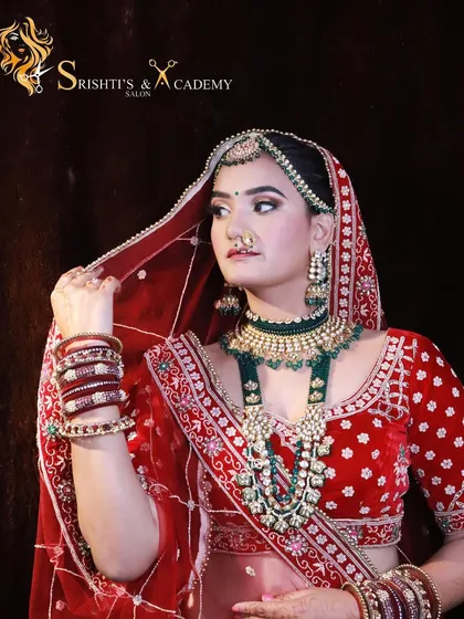 A classic North Indian bridal portrait in a red lehenga, showcasing the elegant makeup and poise we teach our models and students to capture.