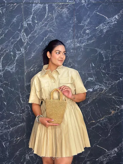 Holding it as a handbag emphasizes its structured shape and adorable top handles. It's a small bag that packs a lot of style.