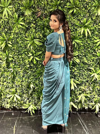 The back view of our teal draped dhoti set, showing the elegant tie-up detail on the blouse and the beautiful flow of the draped pants.