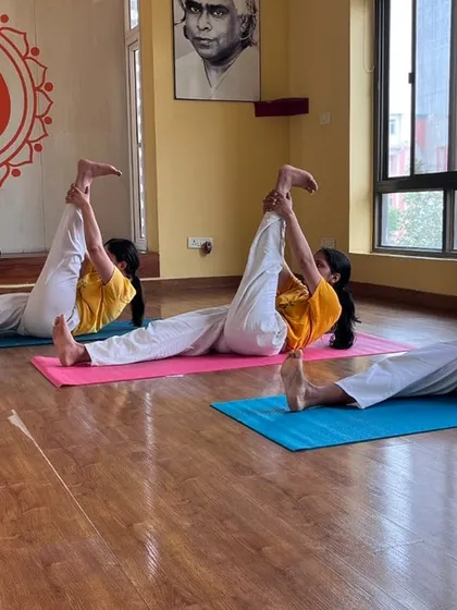 Students practice a leg-stretching asana, building flexibility and control. Our beginner course systematically introduces all 12 basic postures of the Sivananda sequence.