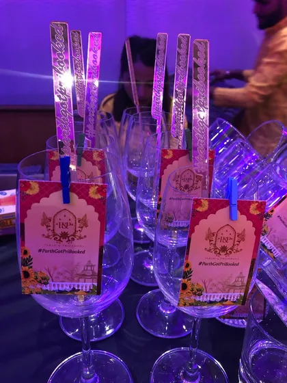 Custom-designed tags and stirrers for a wedding. These details carry the event's theme and hashtag right to the cocktails.