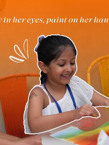 "Joy in her eyes, paint on her hands." This image perfectly captures a moment of pure happiness as a young girl enjoys a painting session.