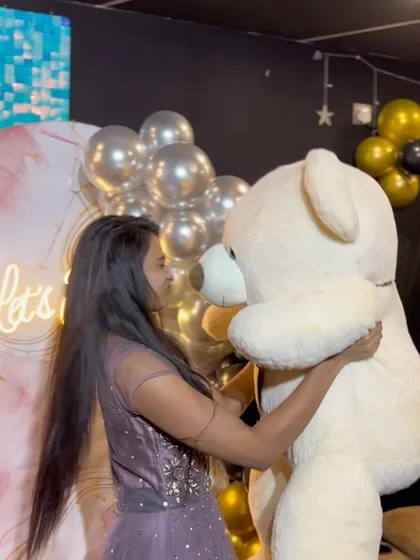 A happy guest celebrating her 27th birthday in style, hugging a giant teddy bear. Our spaces are designed for fun and memorable photo ops, making every birthday feel magical.