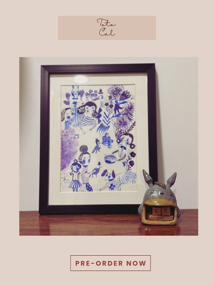 The "Toto Cal" ceramic calendar, styled on a desk next to a beautiful piece of art. It's a functional and whimsical addition to any workspace.