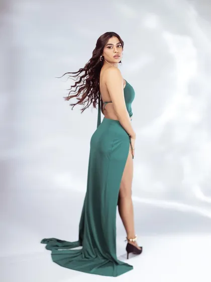 Capturing movement is everything in fashion photography. This shot, with the hair flip and flowing dress against a clean studio background, creates a dynamic and energetic portrait for a model's portfolio.