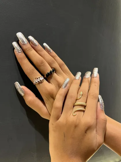 For ultimate sparkle, this set uses a full-coverage silver glitter polish on long, square-shaped nails. It's a high-impact look that is perfect for parties and special events.