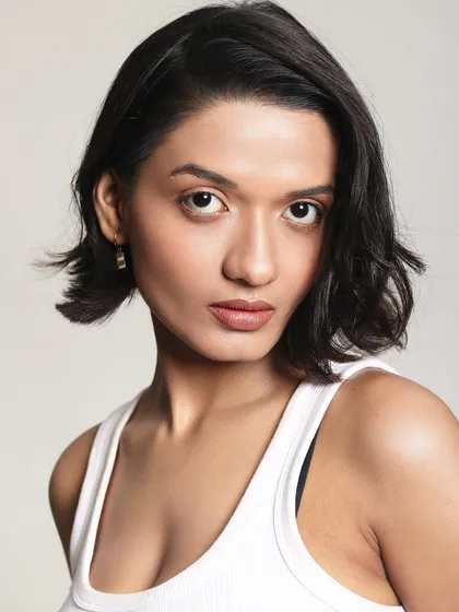 A clean and modern headshot. The makeup is minimal and the hair is styled in a chic, short bob. It's a look that is both professional and stylish.