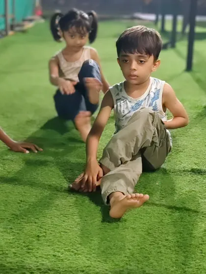 Working on flexibility is just as important as building strength. These young athletes are practicing their stretches on the turf, improving their range of motion.