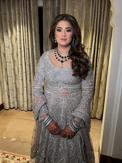 The full look, showcasing a heavily embellished silver lehenga. The hair and makeup are styled to be elegant and timeless.