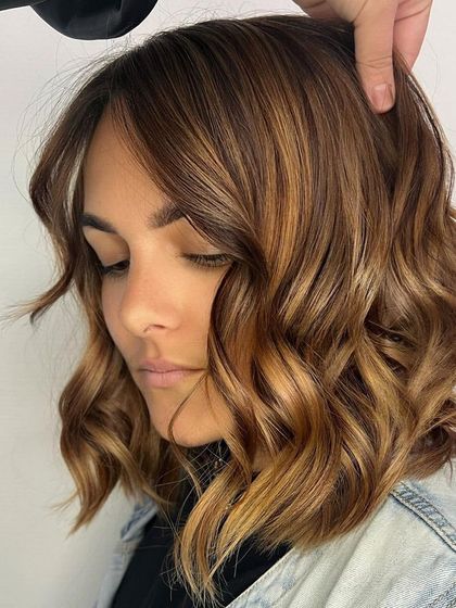 Caramel balayage brings a beautiful warmth and richness to the hair. This style features hand painted caramel highlights on a bob haircut, creating a customized look that reflects the client's personality and style.