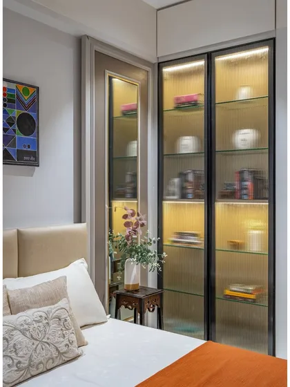 The fluted glass on the display cabinet adds texture and visual interest while partially obscuring the contents. Integrated lighting highlights the displayed items beautifully.